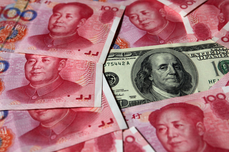 © Reuters. FILE PHOTO: A U.S. $100 banknote is placed next to 100 уuan banknotes in this picture illustration taken in Beijing