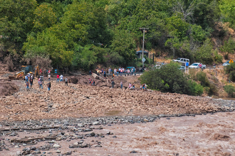 © Reuters. People walk along a damage road after a flood near Santiago, Chile